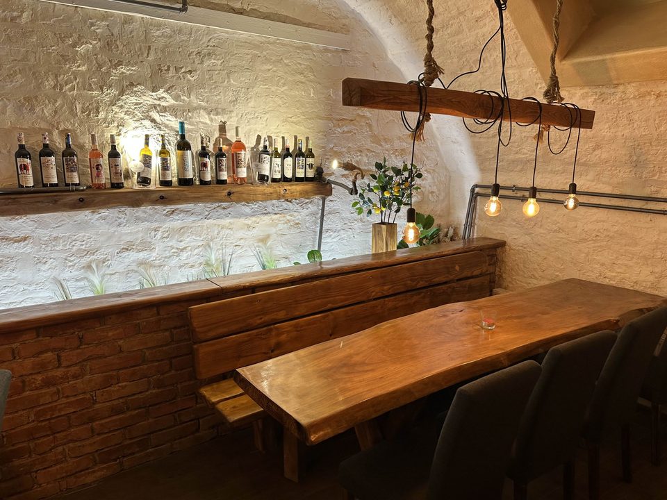 Gewölbekeller des Unique mit Natursteingewölbe und langer Holztafel